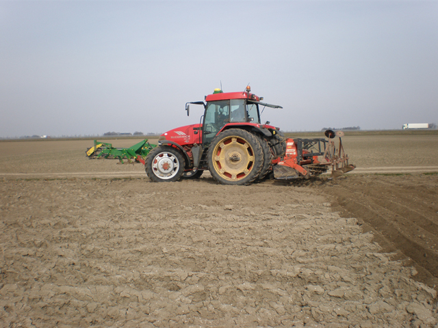 Voordat de pootmachine de aardappelen in de grond kan stoppen, wordt het land bewerkt.